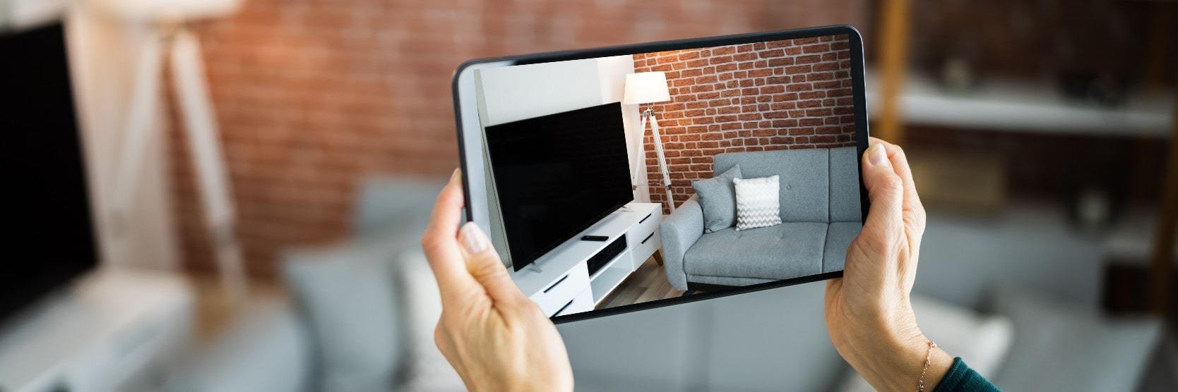 Person holding a tablet with images of a home for a virtual real estate tour